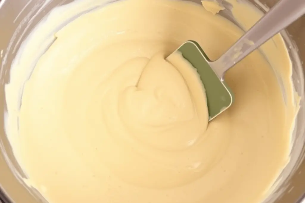 Rich butterbeer cheesecake batter being mixed to a smooth and velvety texture, ready to be poured over the crust.