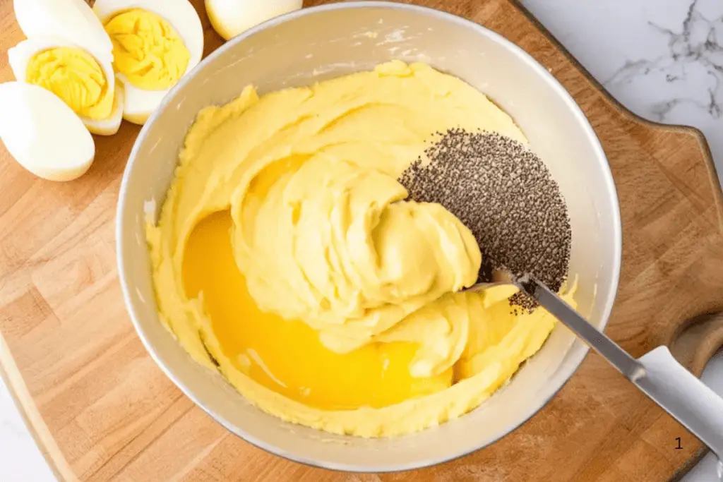 A bowl of mashed egg yolks mixed with mayonnaise and mustard, ready to be piped back into the deviled egg chicks.