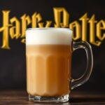 A glass mug of homemade Butterbeer topped with frothy butterscotch foam and drizzled with syrup, ready to serve.